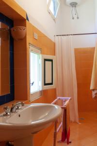 Villa Aimone في مارينا بورتو: حمام مع حوض أبيض ونافذة