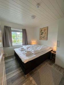 1 cama grande en un dormitorio con ventana en Sennesvik Apartments Lofoten, en Sennesvik
