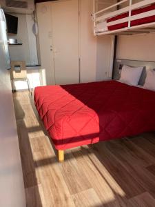 uma cama num quarto com um cobertor vermelho em Premiere Classe La Rochelle Sud - Angoulins em Angoulins-sur-Mer