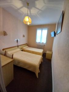 Giường trong phòng chung tại Hôtel Hélios