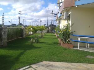 une cour avec de l'herbe verte, une clôture et une maison dans l'établissement MK Express Hotel, à Aracaju