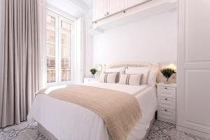 Un dormitorio blanco con una cama grande y una ventana en Genteel Home Marín García, en Málaga