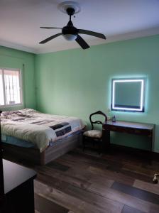 a bedroom with a bed and a ceiling fan at Casa Hormaza in Chiclana de la Frontera