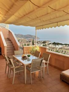 a table and chairs on a balcony with a view at Penthouse Mojon Hills in Isla Plana