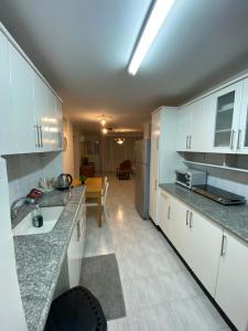 uma cozinha com armários brancos e uma bancada em סוויטה נוף בהרים צפת em Safed