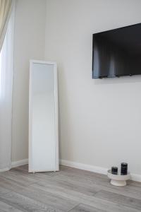Habitación con espejo y TV en la pared. en TEILOR Apartments 5, en Floreşti