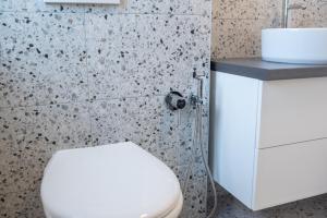 y baño con aseo blanco y lavamanos. en TEILOR Apartments 5, en Floreşti