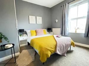 a bedroom with a bed with a yellow blanket at Cosy Home in Historical Beverley Town with Parking in Beverley