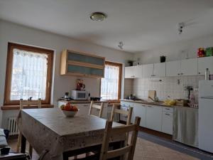 a kitchen with a table with a bowl of fruit on it at Alba Comelico in San Pietro di Cadore