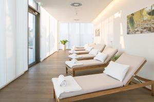una sala de estar con muebles blancos y ventanas grandes. en MAXX by Steigenberger Vienna en Viena