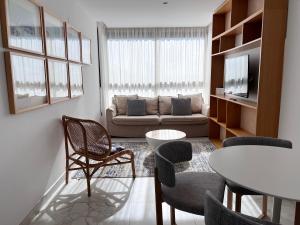 a living room with a couch and a table and chairs at Valencia Luxury - Calma Beach Apartments in Valencia