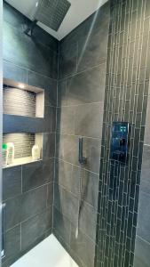 La salle de bains est pourvue d'une douche et d'une paroi en verre. dans l'établissement Kew Gardens - Private Double Room Richmond London - Homestay, à Kew Gardens