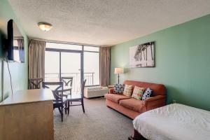 ein Hotelzimmer mit einem Bett, einem Sofa und einem Tisch in der Unterkunft Landmark Resort 936 in Myrtle Beach