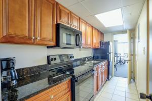 a kitchen with wooden cabinets and a stove top oven at Landmark Resort 936 in Myrtle Beach