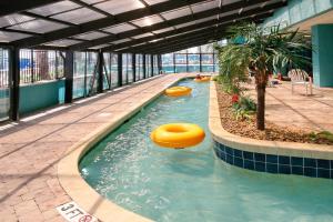 einem Pool in einem Gebäude mit zwei aufblasbaren Gegenständen im Wasser in der Unterkunft Landmark Resort 936 in Myrtle Beach