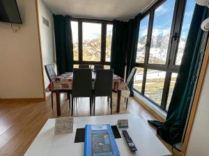 a dining room with a table with chairs and a large window at Apartamentos Princesa Park 3000 in Pas de la Casa