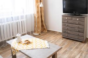 uma sala de estar com uma mesa e uma televisão em In between center and sea appartment em Liepāja