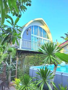 a house with a balcony and a swimming pool at Amantra homestay & village in Suratthani