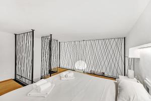 米蘭的住宿－Loft Spritz，一间卧室配有一张带两条白色毛巾的床