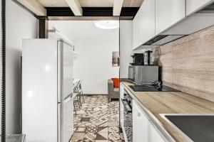 a kitchen with white cabinets and a counter with a microwave at Loft Spritz in Milan
