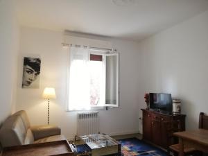 salon z kanapą i telewizorem w obiekcie Appartamento: tranquillità o divertimento w Bolonii