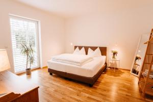 a bedroom with a large bed and a large window at Kaiser's Hof in Strass