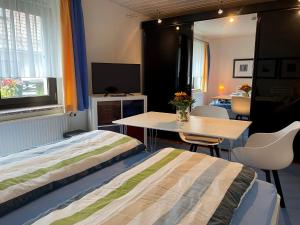 um quarto com uma cama, uma mesa e uma televisão em Privatzimmer Krautzig em Cottbus