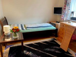 um quarto com uma cama e uma secretária com uma mesa com uma flor em Privatzimmer Krautzig em Cottbus