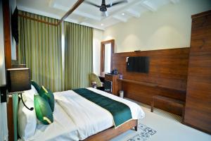a hotel room with a bed and a television at 5 States Resort in Amritsar