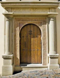 a large wooden door in a building with two columns at Apartamentos Turísticos Casa de La Borrega in Estepona