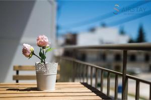 a vase with pink flowers sitting on a table at Anivia Apartments Airport by Airstay in Spata