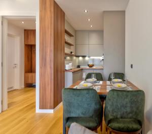 una cucina e una sala da pranzo con tavolo e sedie di Apartman MONTANA Vila Luna a Zlatibor