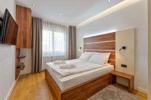 una camera da letto con un letto grande con testiera in legno di Apartman MONTANA Vila Luna a Zlatibor