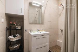 a white bathroom with a sink and a shower at Anivia Apartments Airport by Airstay in Sp&aacute;ta