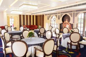 a banquet hall with tables and chairs and a statue at 5 States Resort in Amritsar