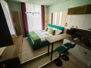 Habitación pequeña con cama y mesa. en Dream Apartments en Szeged