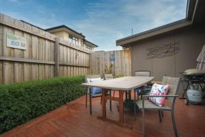 a patio with a table and chairs and a fence at Argo Sands, Steps From The Beach! in Rosebud