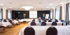 a conference room with white tables and chairs and a screen at Straelener Hof in Straelen