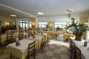 a restaurant with tables and chairs with yellow table cloth at Hotel Ganfo in Sirmione