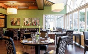 a restaurant with tables and chairs and windows at Straelener Hof in Straelen