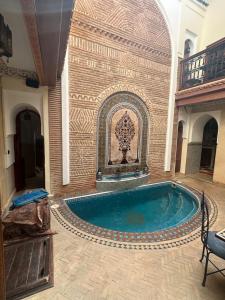 a large swimming pool in a building with a wall at Riad Bonheur in Marrakesh