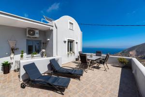 a patio with chairs and a table and the ocean at Horizon Sky House with view in Pirgos