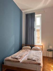 Cama en habitación azul con ventana en Apartament Meiselsa, en Cracovia
