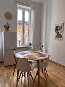 cocina con mesa, sillas y nevera en Apartament Meiselsa, en Cracovia