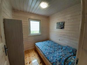 a small bedroom with a bed in a room with a window at Na Wydmie in Wicie