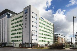 a large building with a large building behind it at ibis budget Manchester Salford Quays in Manchester
