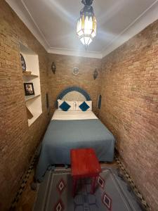 una piccola camera con letto e tavolo rosso di Riad Bonheur a Marrakech