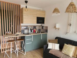 sala de estar con cocina y sofá en Joli Studio cavalaire en Cavalaire-sur-Mer