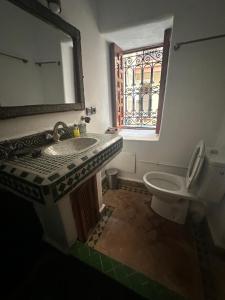 bagno con lavandino, servizi igienici e finestra di Riad Bonheur a Marrakech
