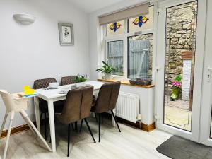 a dining room with a table and chairs and a window at Cosy Heather Cottage in Ashbourne